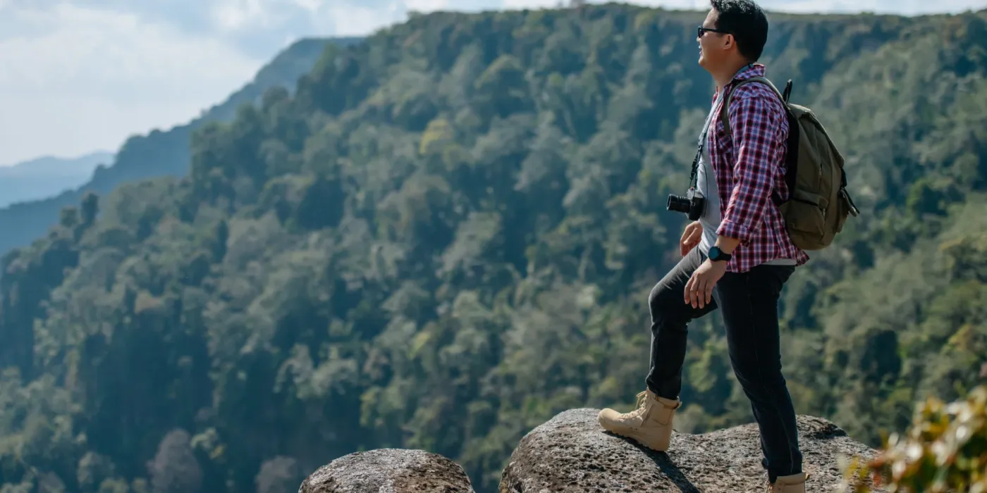 side-view-young-asian-hiking-man-standing-riseup-hands-with-happy-peak-rocky-mountain-beautiful-landscape-background